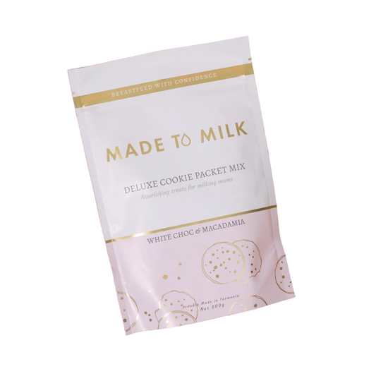 Made to Milk cookie packet mix white choc and macadamia on a pink background with cookies and ingredients.