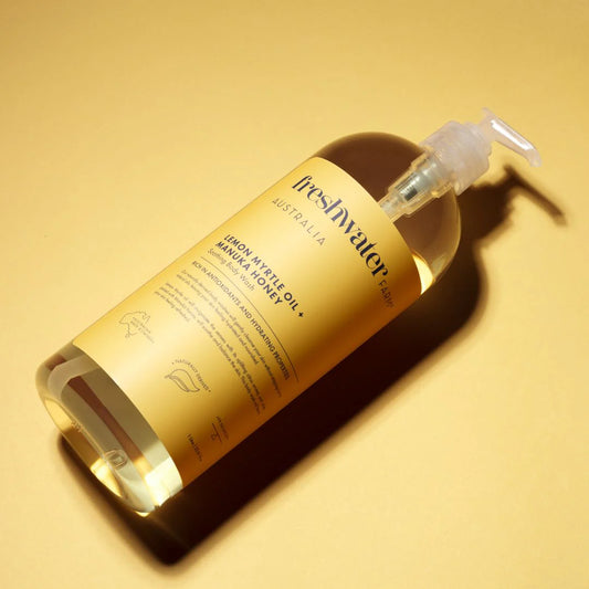 Bottle of Freshwater Australia body wash lemon myrtle oil + manuka honey product on a yellow background