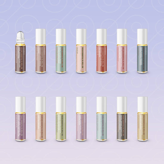 Row of small bottles with metallic caps on a light purple background