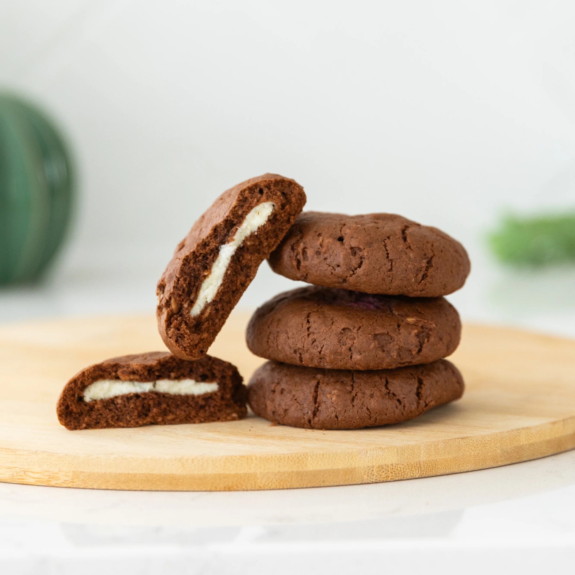 Chocolate mint lactation cookies with a white mint filling on a wooden board