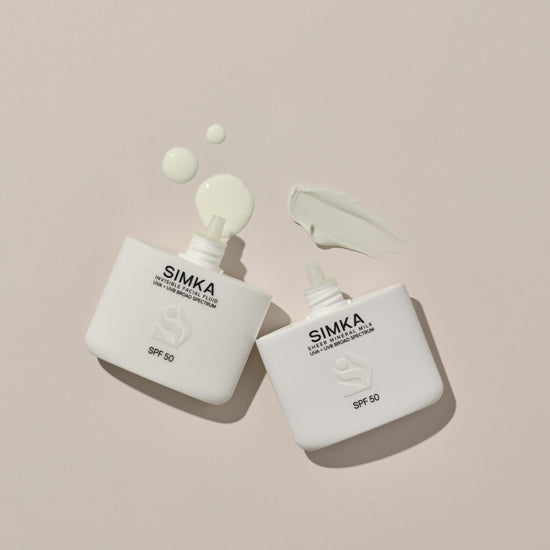Two SIMKA sunscreen bottles with a beige background