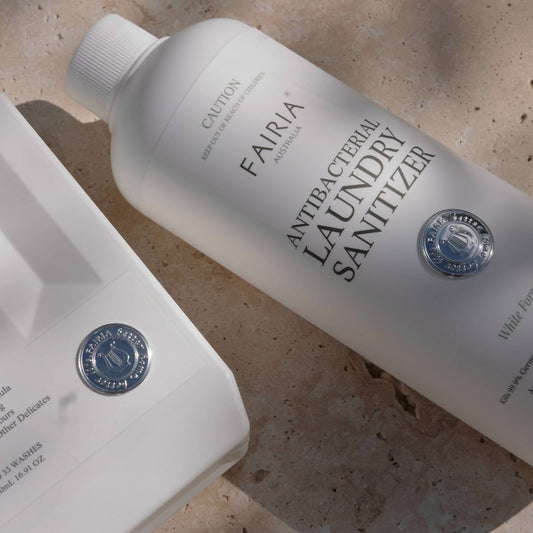 FAIRIA laundry sanitizer bottles on a marble textured surface