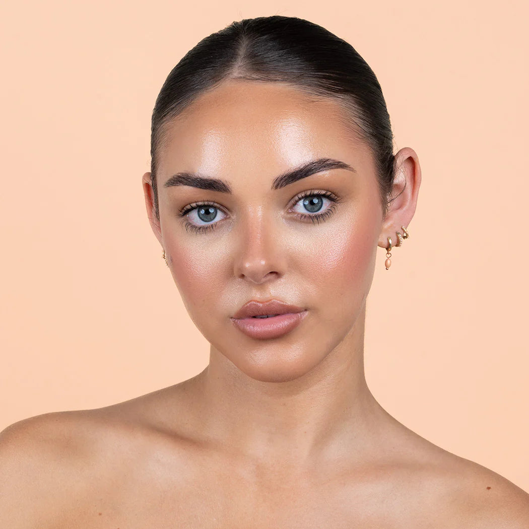 Woman with a neutral expression with bronzing drops on
