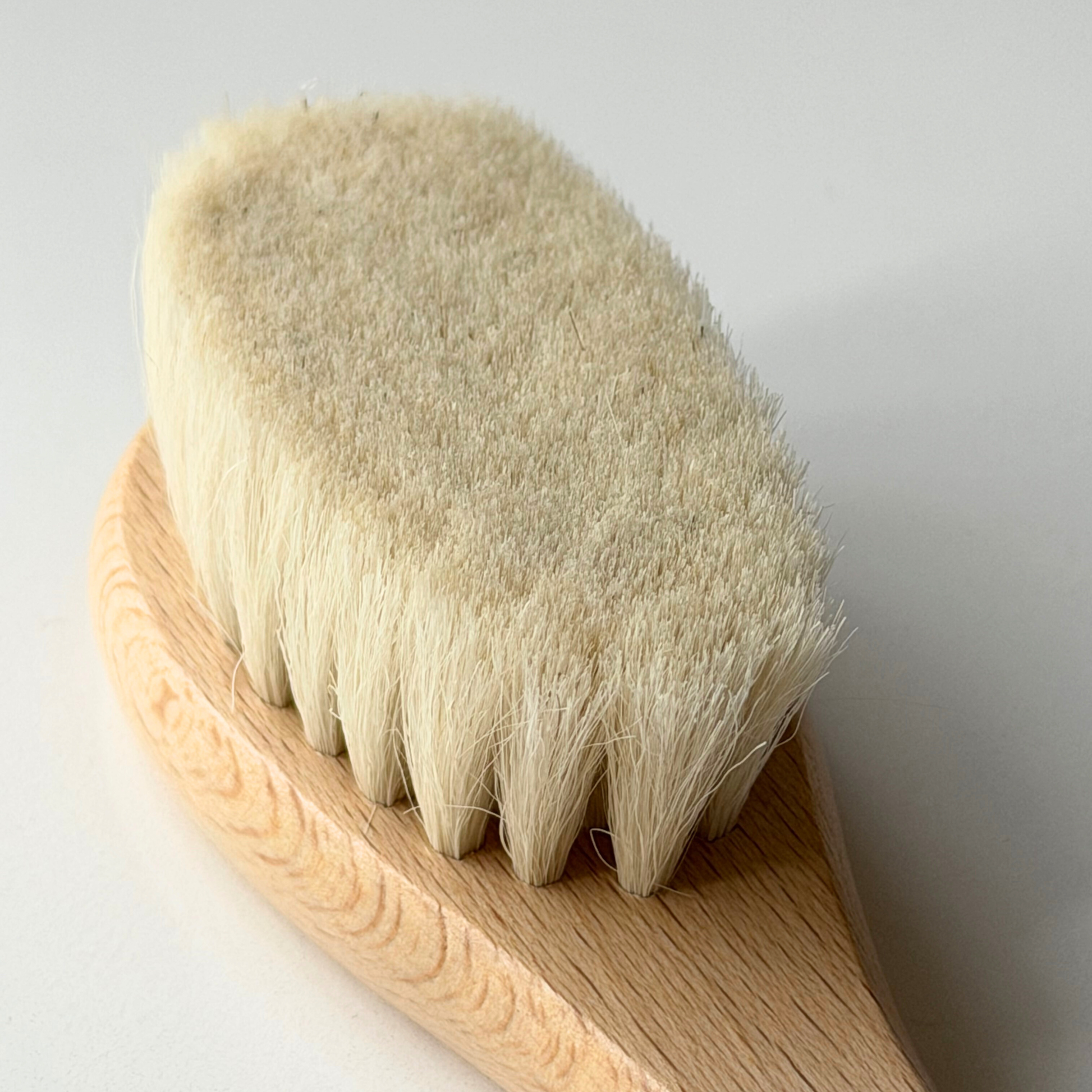 Wooden baby brush with bristles on a light gray background