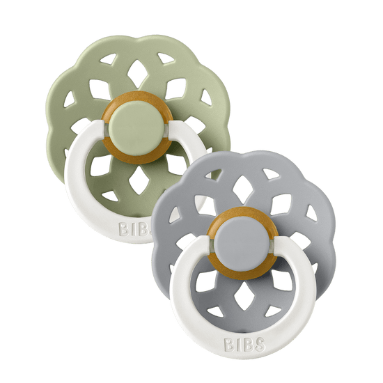 Set of two BIBS Boheme pacifiers featuring sage and blue colours, flower-style silicone shields, and white ring handles—premium baby soothers for newborns and infants. Glow in the dark, round, size one.