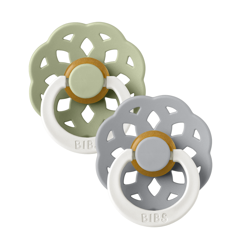 Set of two BIBS Boheme pacifiers featuring sage and blue colours, flower-style silicone shields, and white ring handles—premium baby soothers for newborns and infants. Glow in the dark, round, size one.