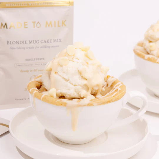 Blondie mug cake with ice cream in a white cup next to a 'Made to Milk' product.