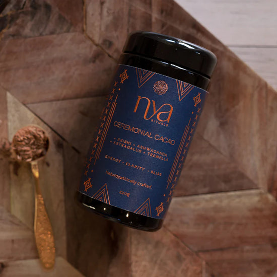 Nya ceremonial cacao container on a stone surface with a gold spoon.