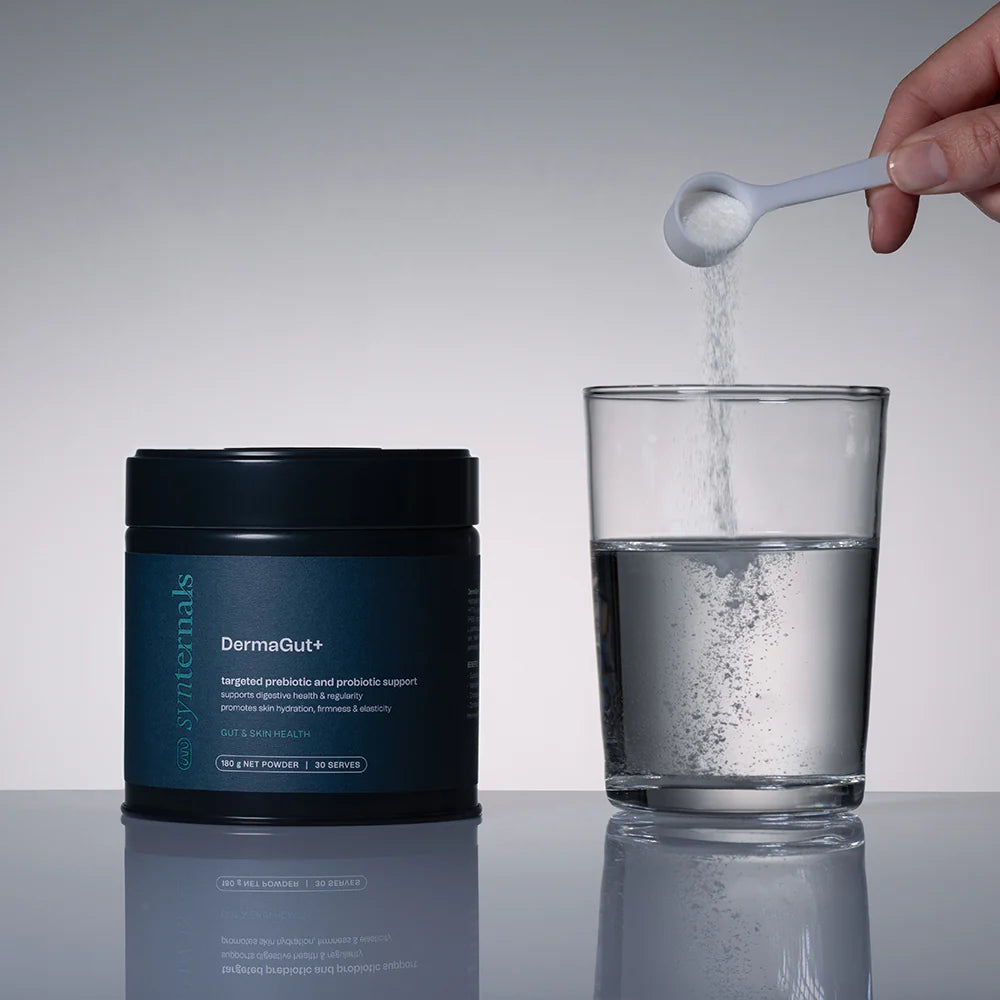 DermaGut+ supplement container with a glass of water and a spoonful of powder being added.