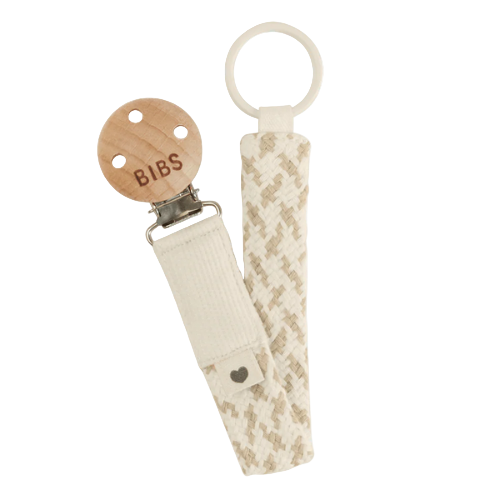 Dummy clip or Pacifier clip. Light timber badge that says bibs on top of metal clip attached. Braided cotton band in ivory and vanilla with dummy ring on end. 