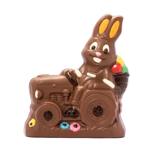 Chocolate bunny riding a tractor with colorful candies on a white background