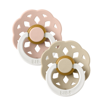 Set of two BIBS Boheme pacifiers featuring blush and vanilla colours, flower-style silicone shields, and white ring handles—premium baby soothers for newborns and infants. Glow in the dark, round, size one.