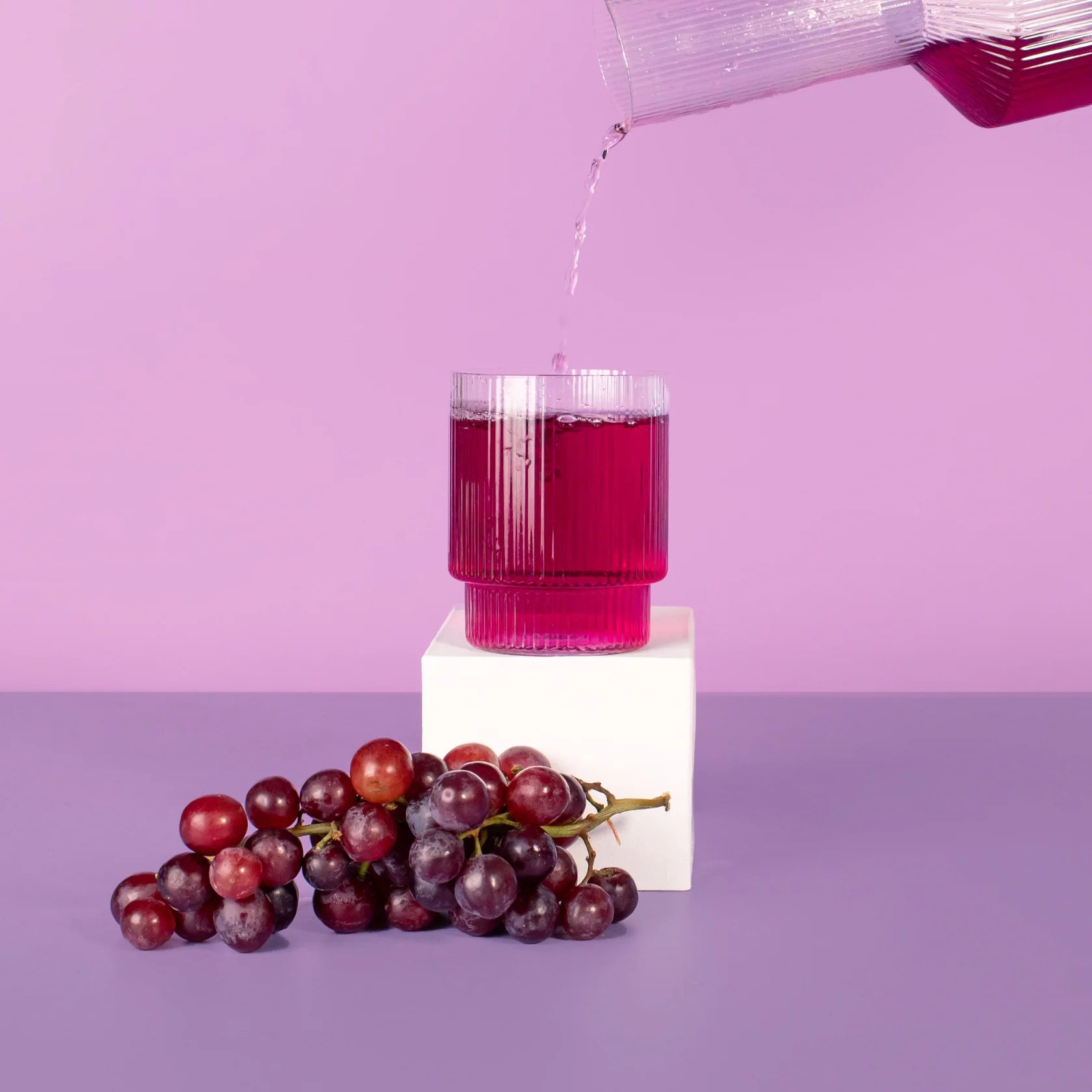 grape hydramama being poured into glass with grapes sitting