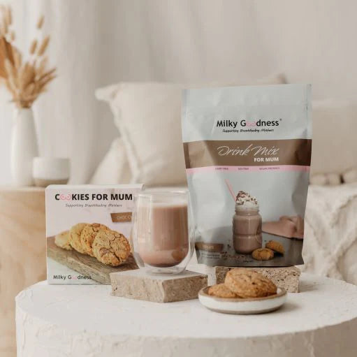 Milky Goodness lactation drink mix and cookies on a table with a neutral background