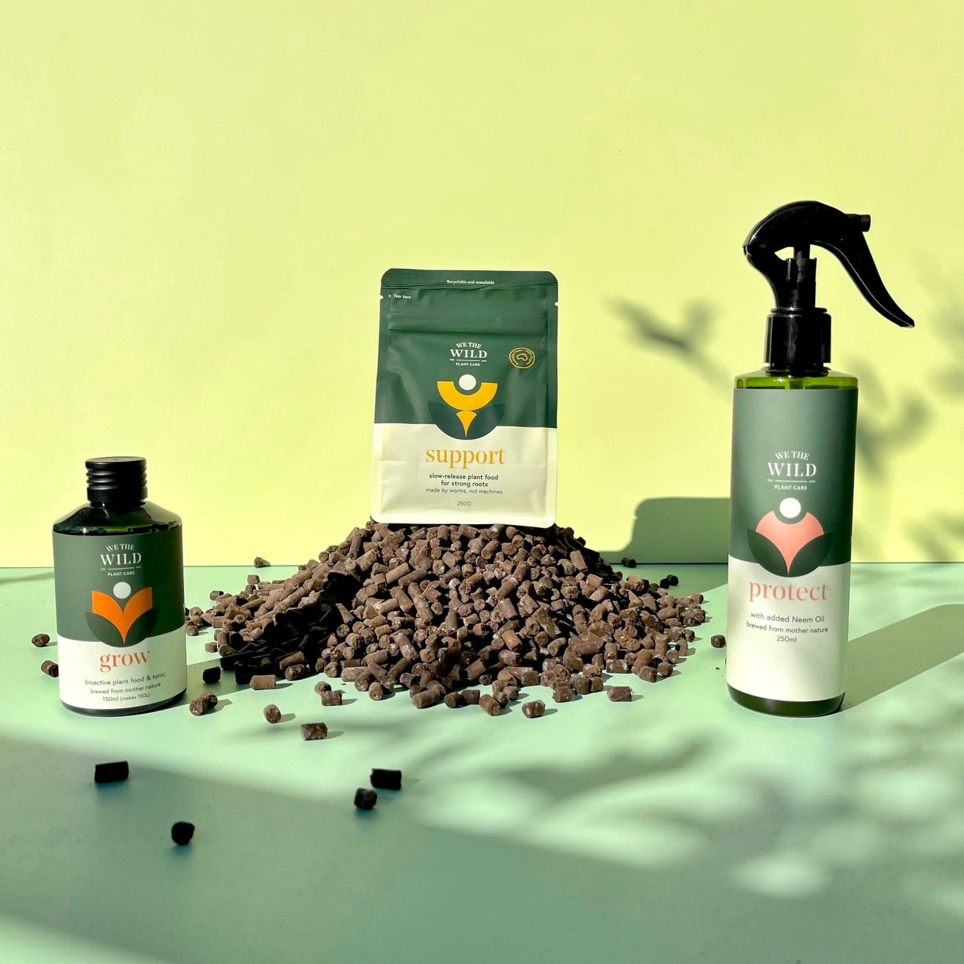 Three plant care products on a green surface with a yellow background. Grow, support and protect.