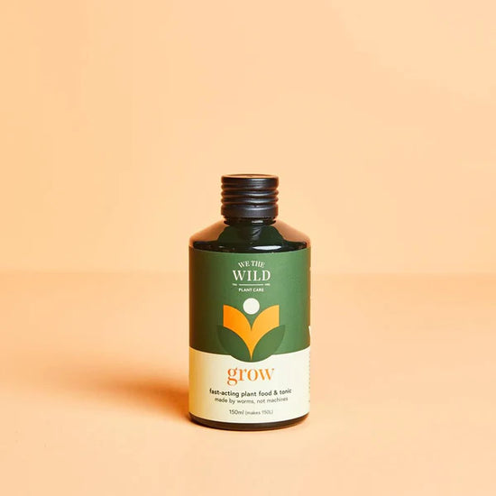Bottle of 'We The Wild' Grow Concentrate Organic Liquid Plant Food on a beige background
