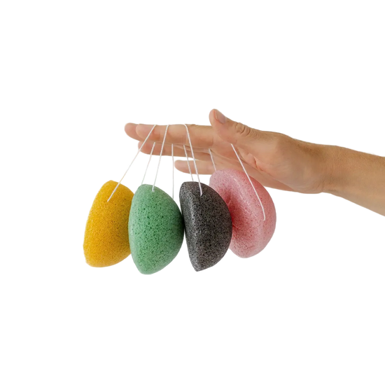 Four colorful konjac sponges hanging from a string against a white background