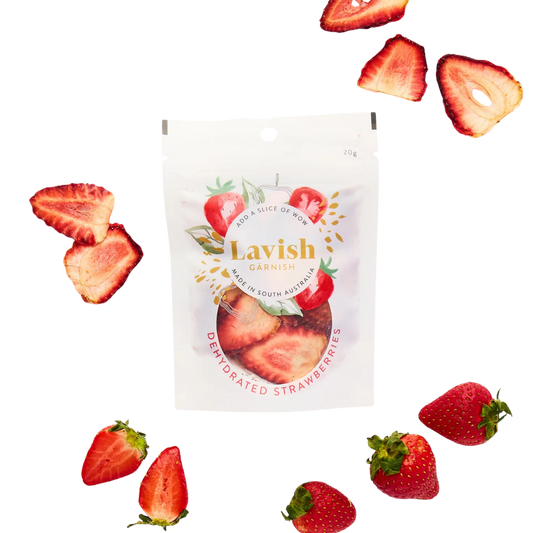 Lavish Garnish dehydrated strawberries packaging with scattered strawberries on a white background