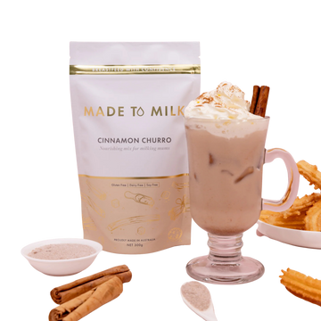 Made to Milk cinnamon churro flavor package with a glass of hot chocolate, whipped cream, and cinnamon sticks.
