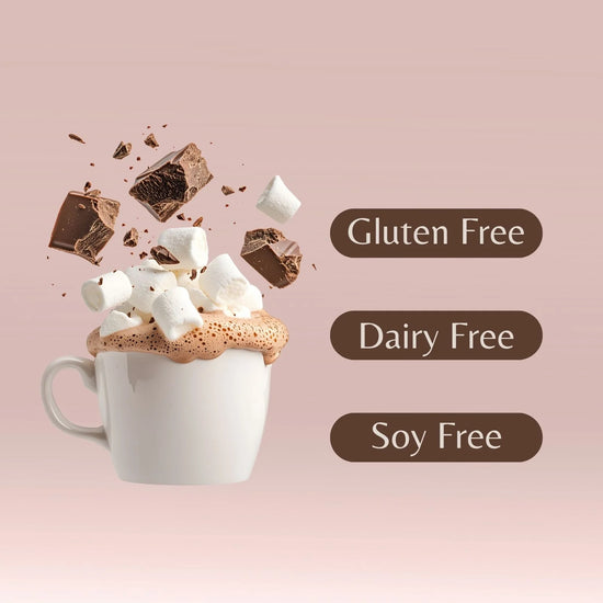Hot chocolate with marshmallows and chocolate pieces on a pink background, labeled as gluten free, dairy free, and soy free.