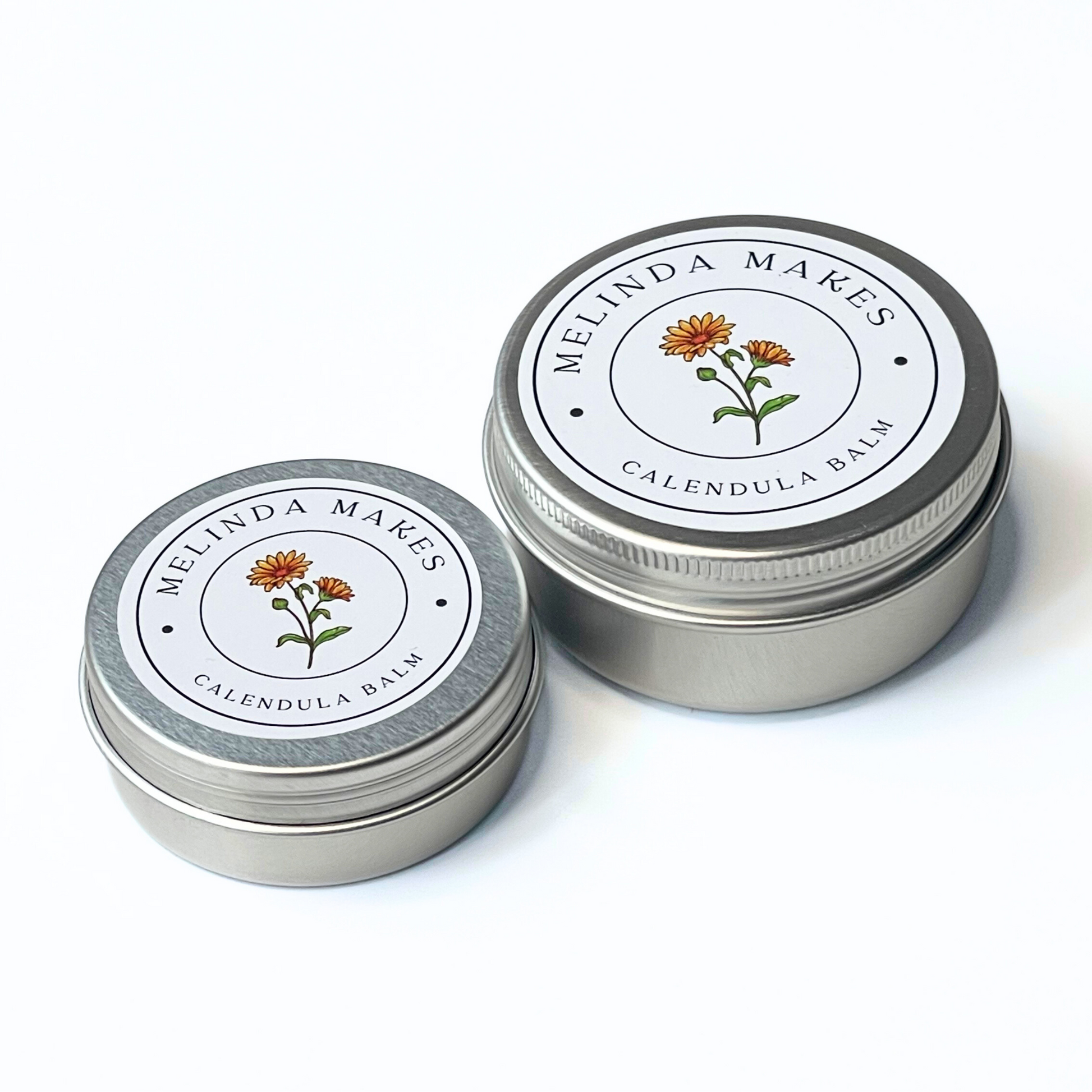 Both size tins of Melinda Makes Calendula Balm with calendula floral on it on a white background