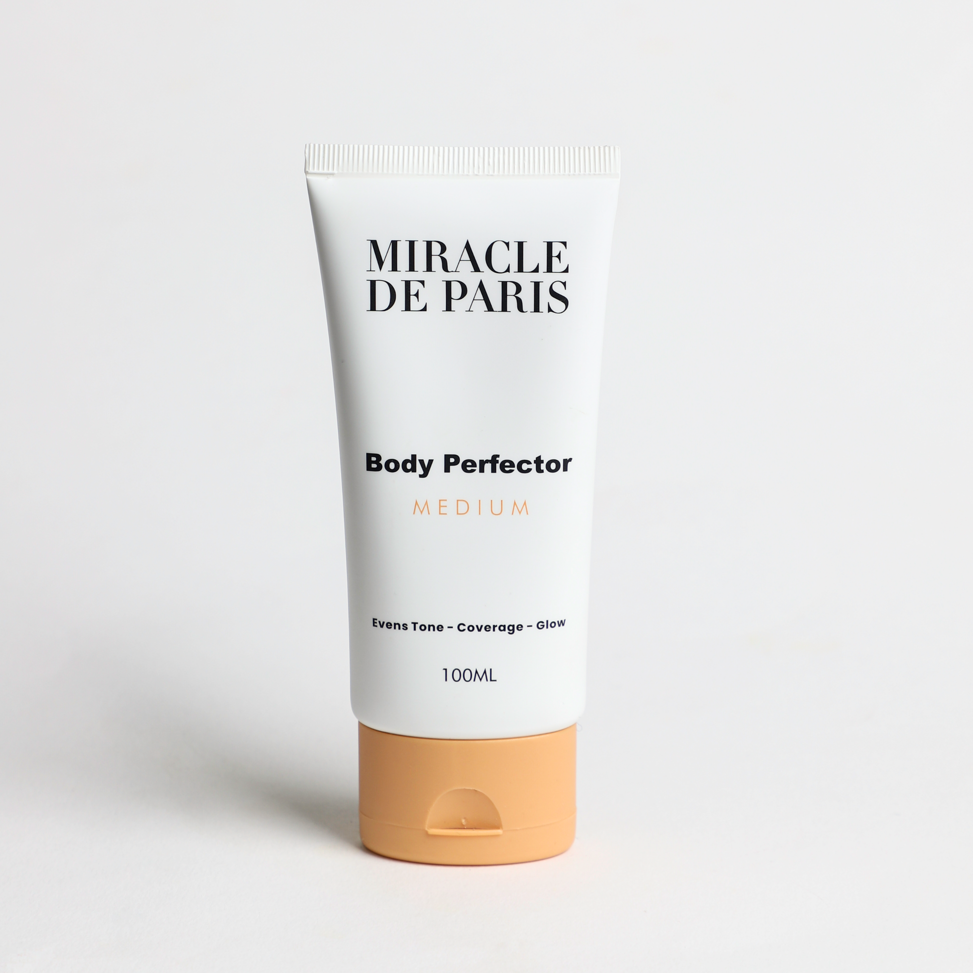 Tube of Medium Miracle de Paris Body Perfector on a light gray background
