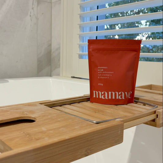 Mumma's Scrub Red package of 'mamave' on a wooden bath tray with a bathtub and window in the background.