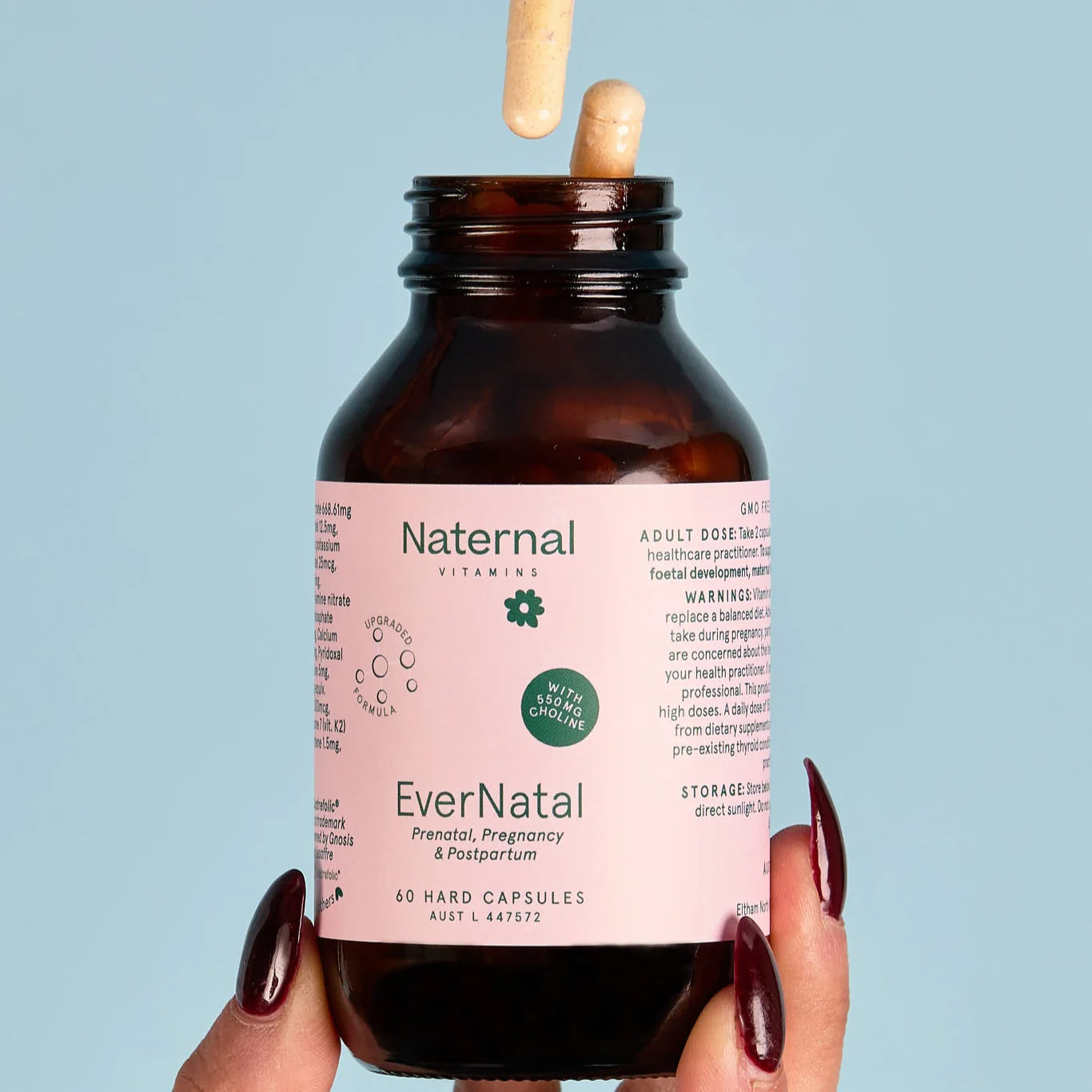 Brown bottle labeled 'EverNatal' held by a hand against a light blue background