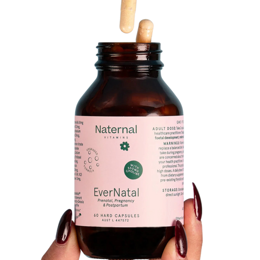 Bottle of Naternal EverNatal prenatal, pregnancy & postpartum vitamins held by a hand with dark nail polish 