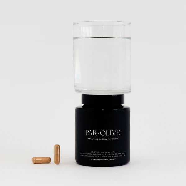 Jar of Par Olive advanced skin multivitamin and glass of water as-well as 2 tablets