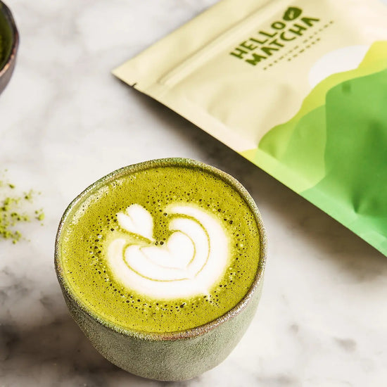 Matcha green tea latte with a 'Hello Matcha' package on a marble surface