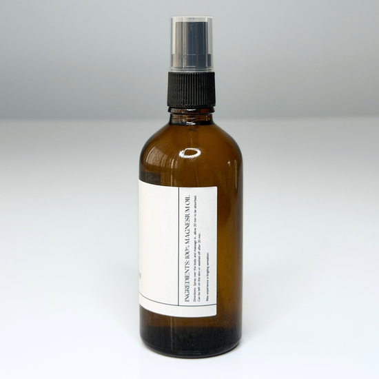 Brown glass bottle with a black spray nozzle on with ingredients on a white background