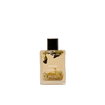 Serenity bath to body oil 100% natural miod glass bottle with black lid and flowers in it. 