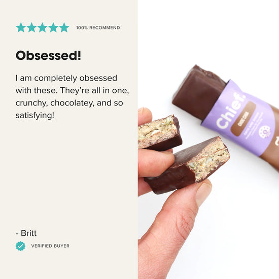 Hand holding a chocolate bar with a review on a white background