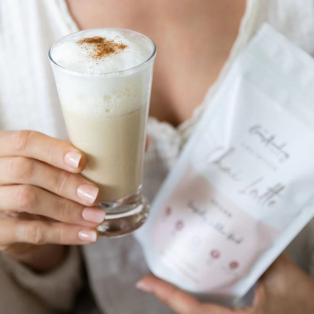 Person holding a glass of lactation chia latte the breastfeeding tea co