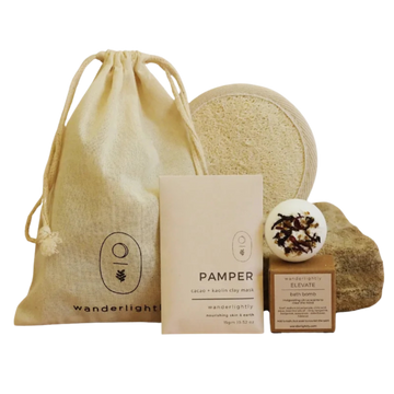 Collection of natural skincare products including a drawstring bag, soap, and bath bombs on a white background. Mini spa hamper 