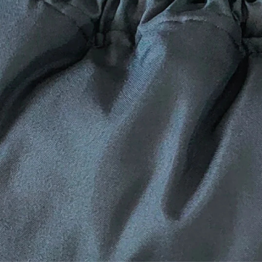 Close-up of a black baby footmuff pram liner 