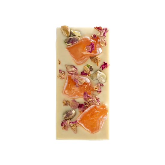 Rectangular white chocolate bar with orange slices and rose petals on a white background