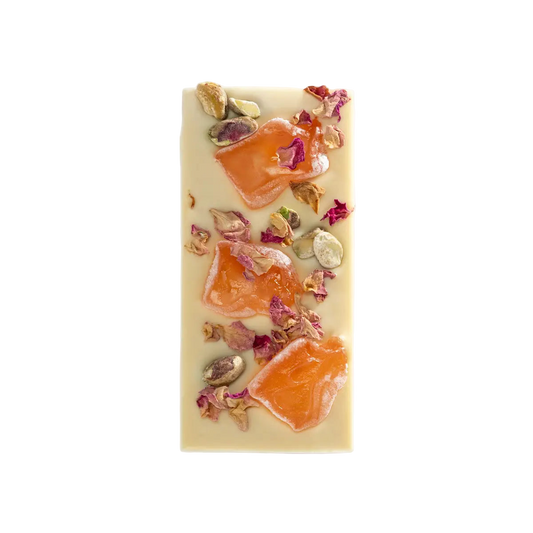 Rectangular white chocolate bar with orange slices and rose petals on a white background