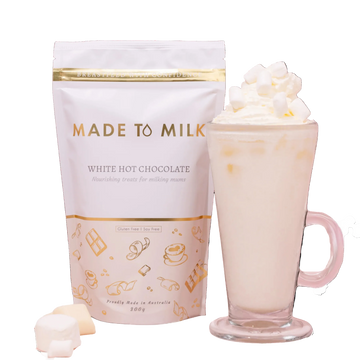 Made to Milk lactation white hot chocolate package with a mug of hot chocolate and whipped cream.