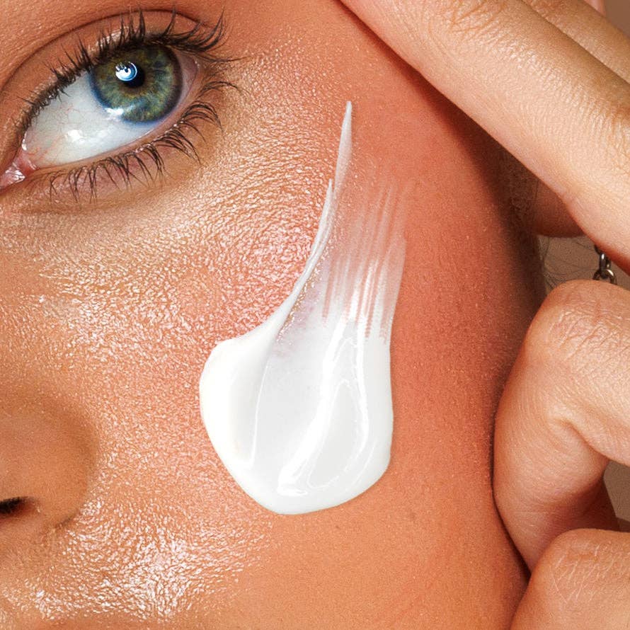 Close-up of a person applying avo zinc swatch cream to their face