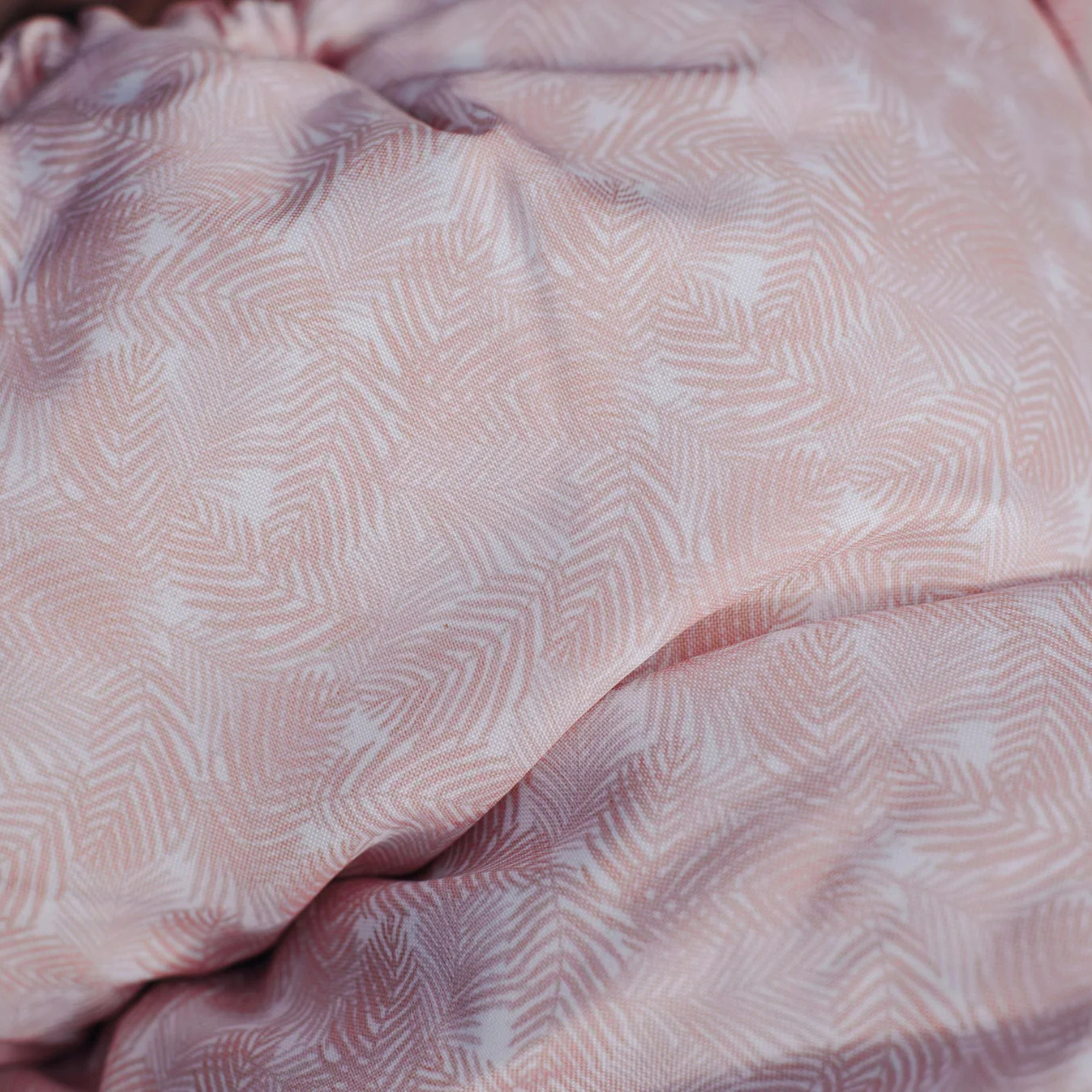Close-up of a pink baby footmuff pram liner 