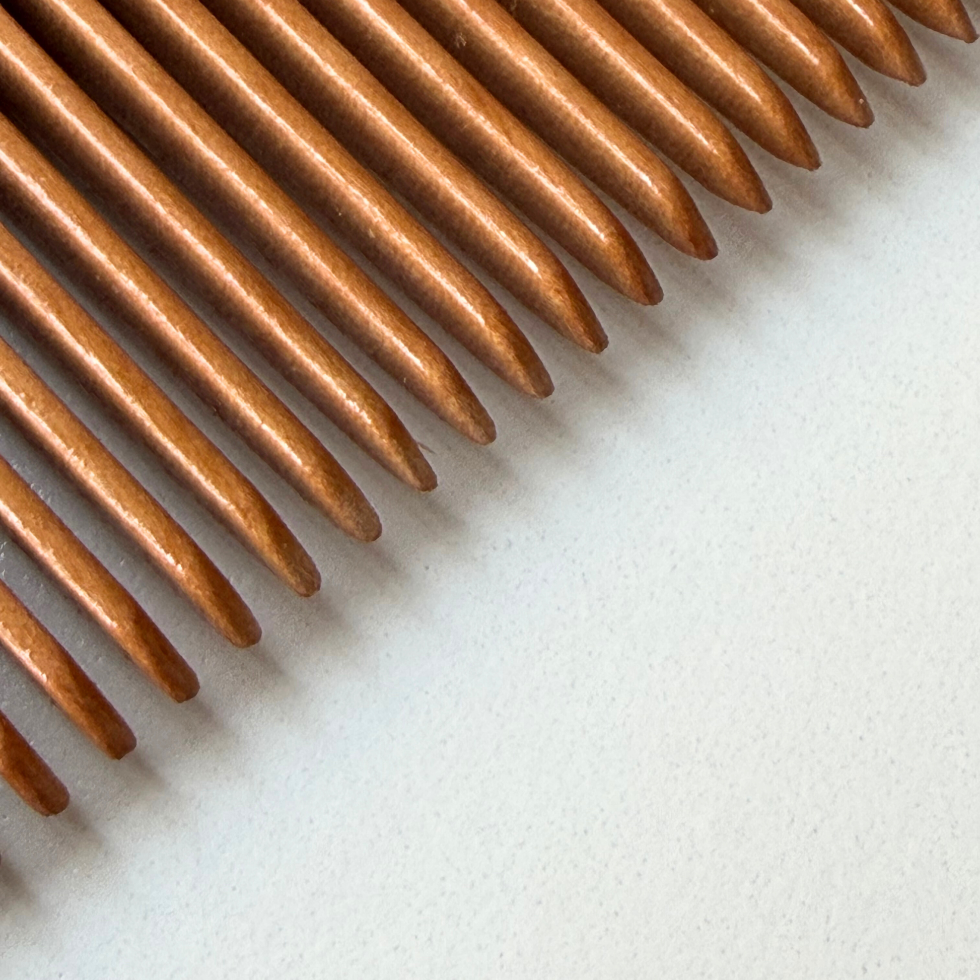 Close-up of labour and birth comb bristles on a white background