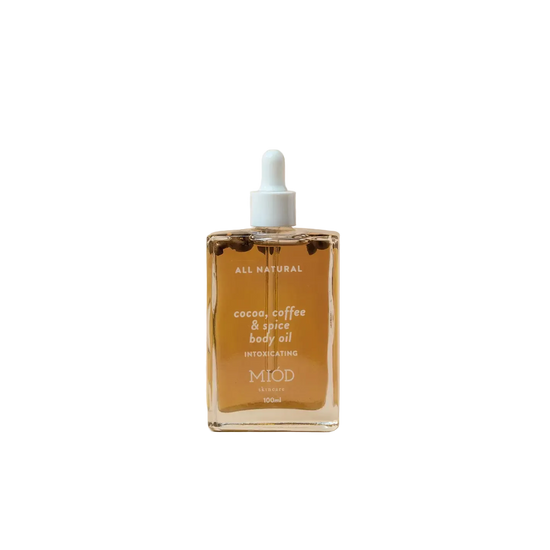 Bottle of Miod cocoa, coffee, & spice body oil on a beige background 100ml