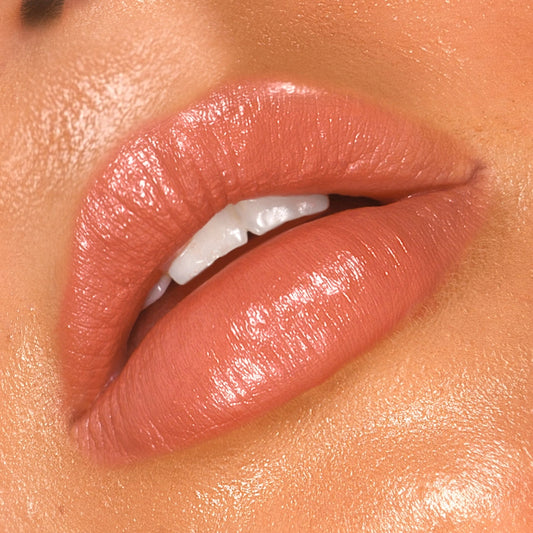 Close-up of a person's lips with a focus on the AvoZinc SPF 50 Natural Lip & Cheek Tint stick in the shade Coral .