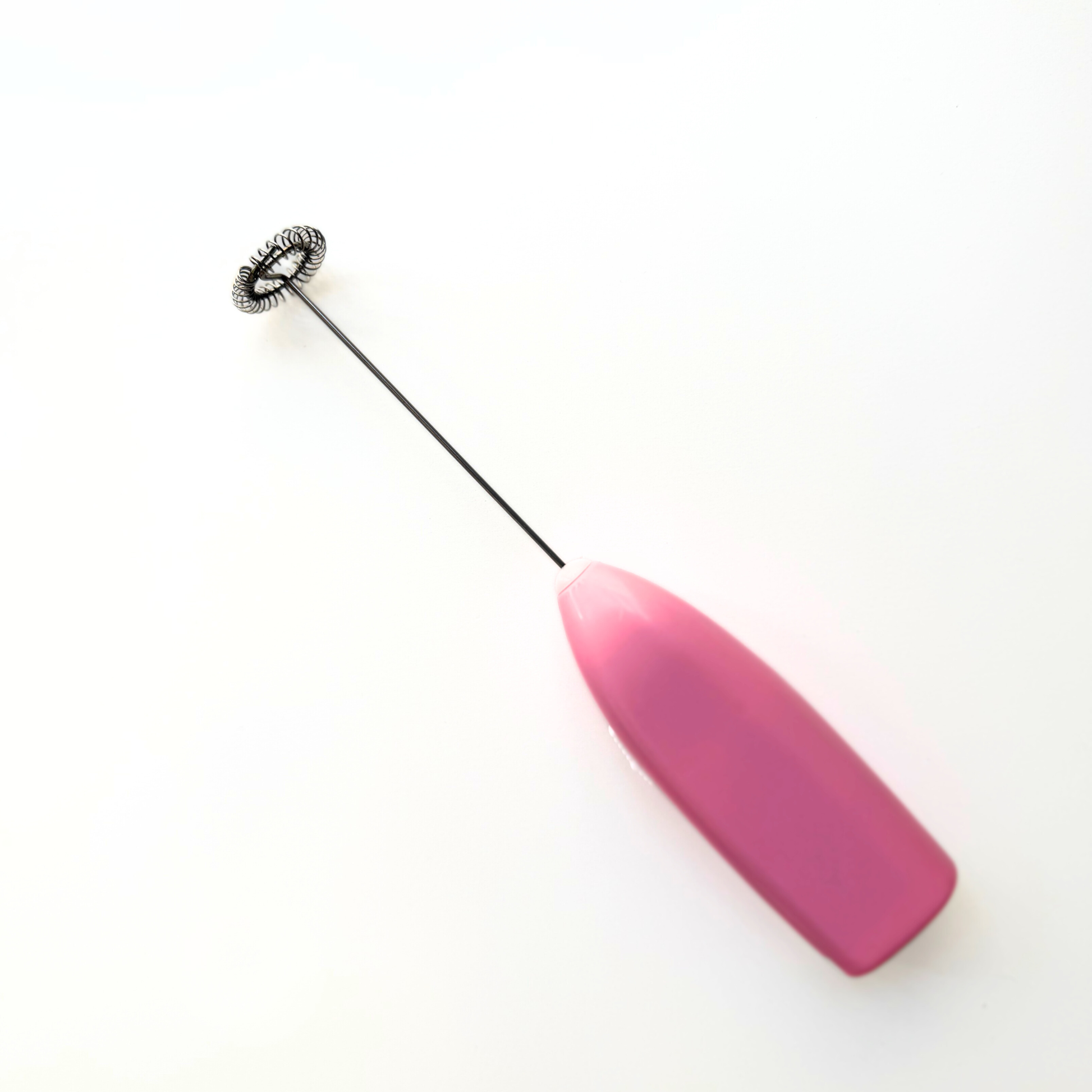 Pink with metal electric whisk on a white background