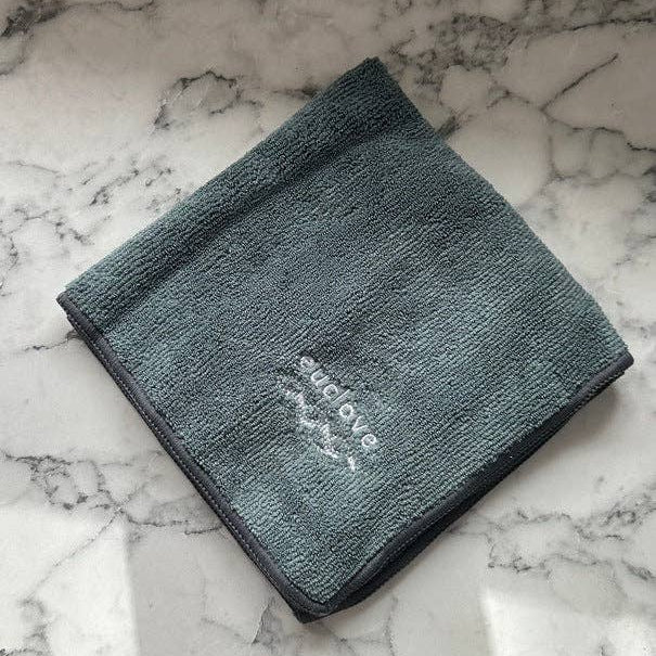 Gray towel with 'EUCLOVE' branding on a marble surface