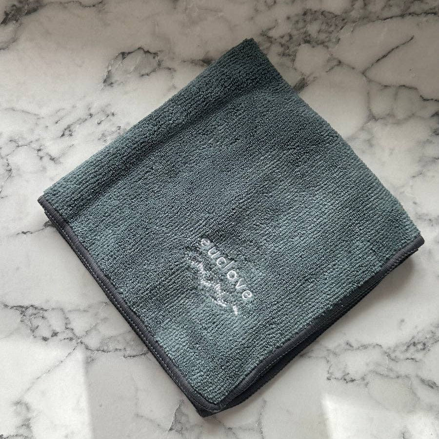 Gray towel with 'Bellaire' branding on a marble surface