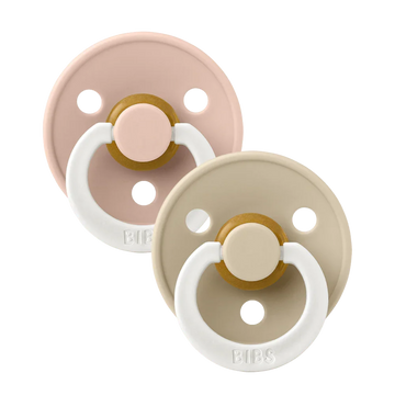 Two baby pacifiers in blush and beige with white rings