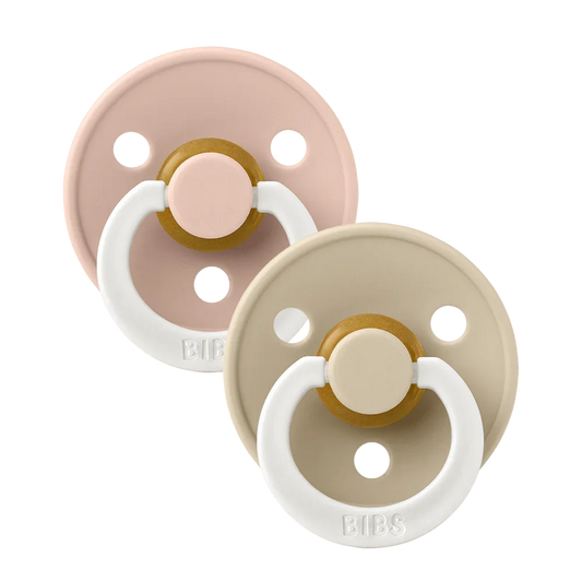 Two baby pacifiers in blush and beige with white rings